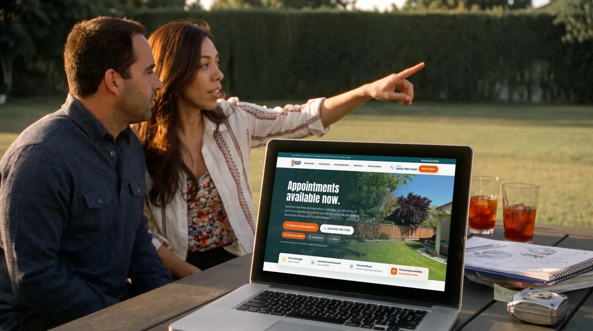 The Fantastic Fence website on a laptop as a couple plans their backyard on the patio