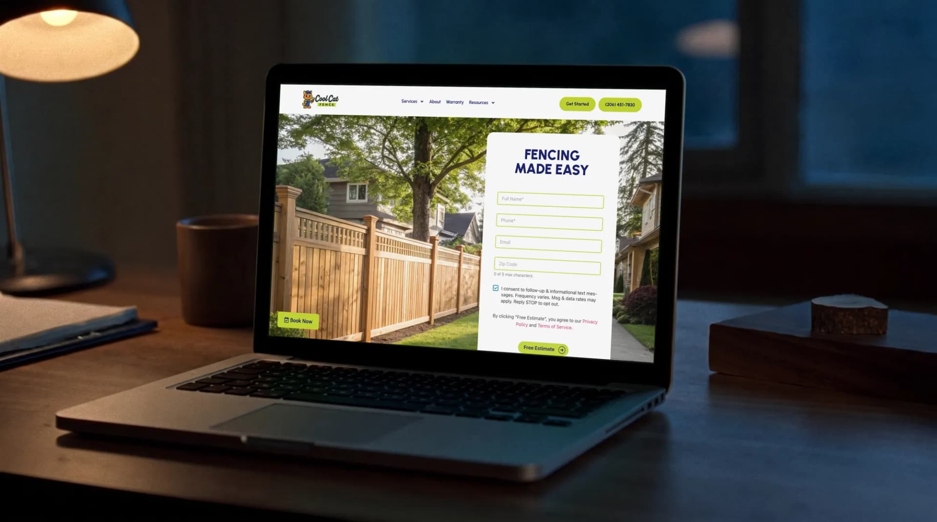 The Cool Cat Fence website on a laptop on a walnut desk in a quiet office at dusk